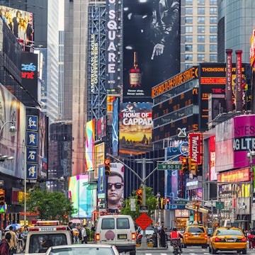 Times square billboards and traffic during the day.