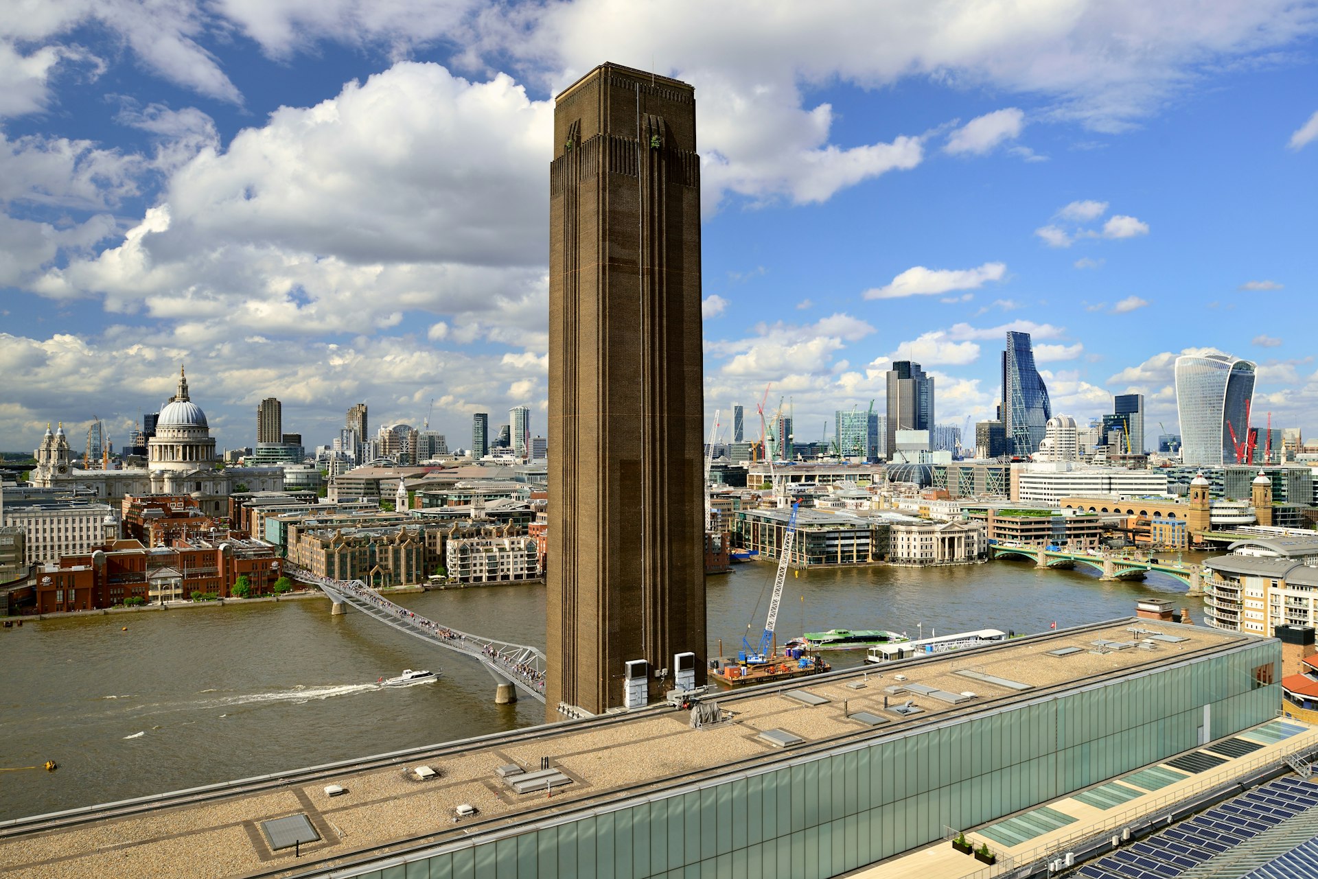 The distinctive brick chimney of Tate Modern art gallery rises up in front of a view of the London skyline across the river Thames