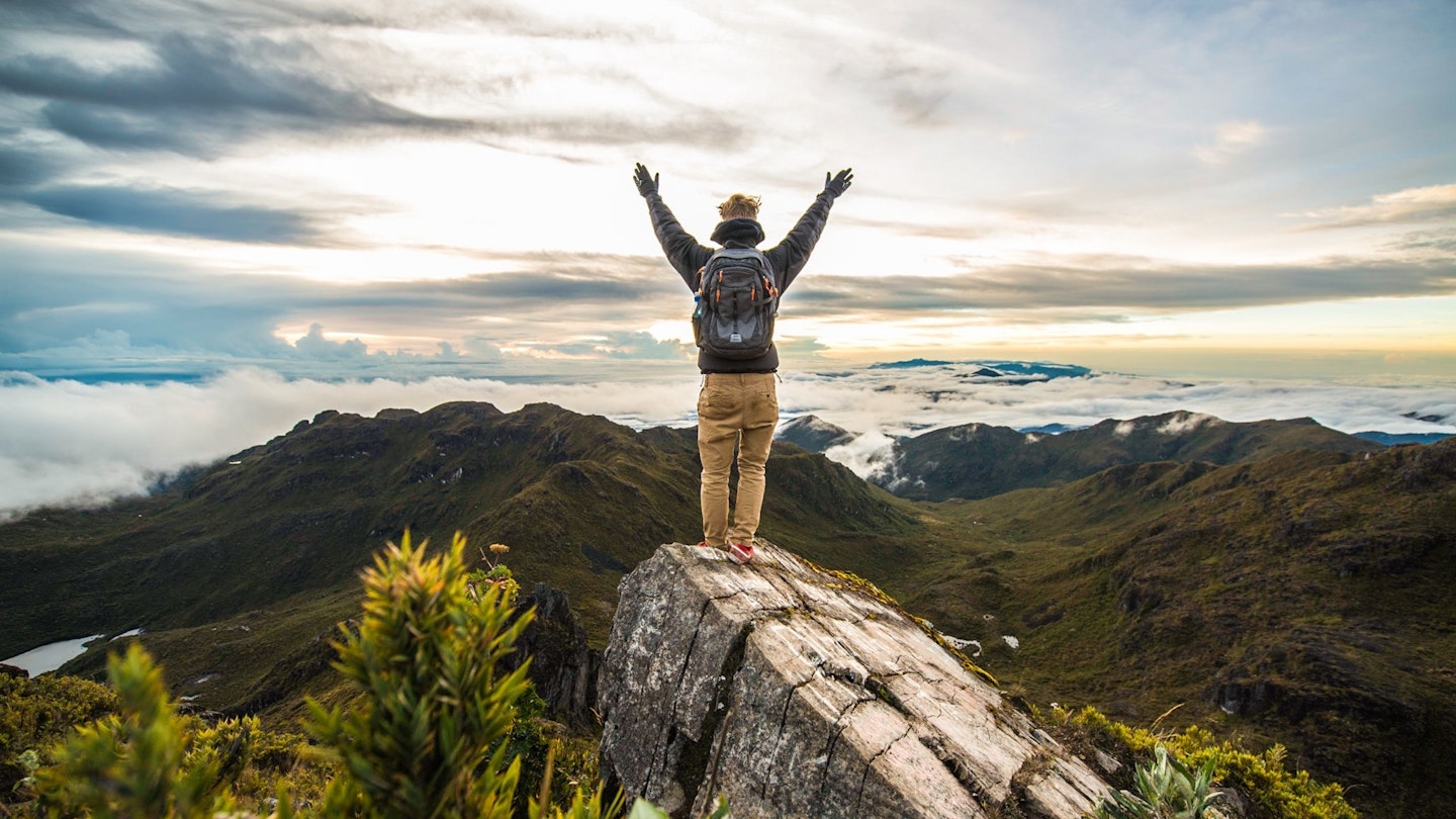 Rear View Of Man With Arms Raised Standing On Rock At Cerro Chirripo