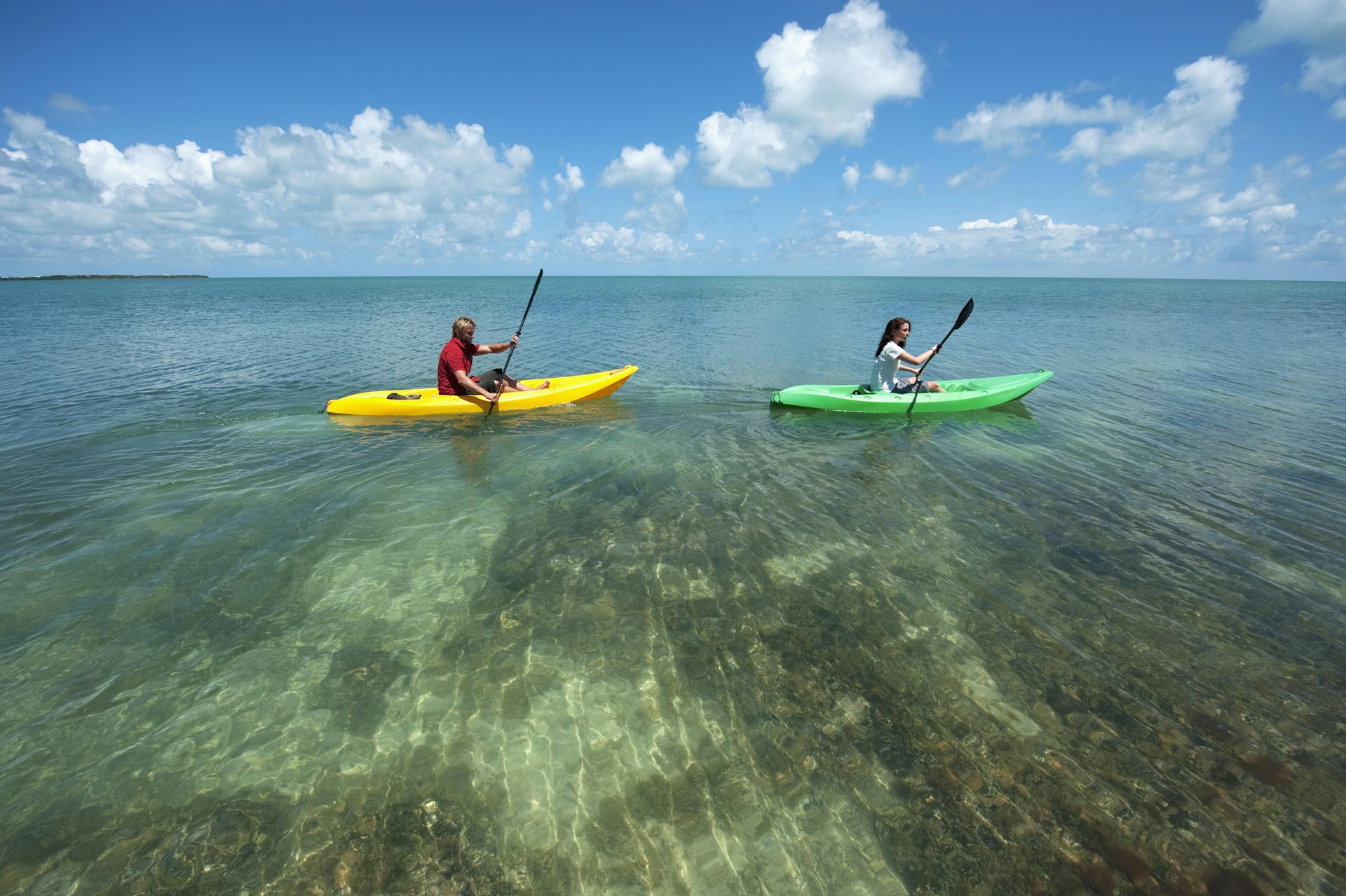 A man and woman kayak in calm waters