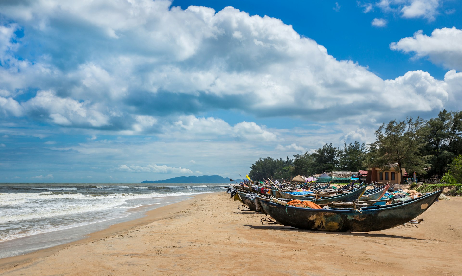A number of fishing boats on the golden sands of Ho Coc beach, Vietnam
