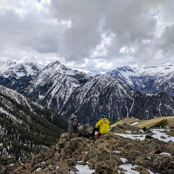A pair of hikers overlook the Wallowa Mountains in eastern Oregon from the summit of Mt Howard