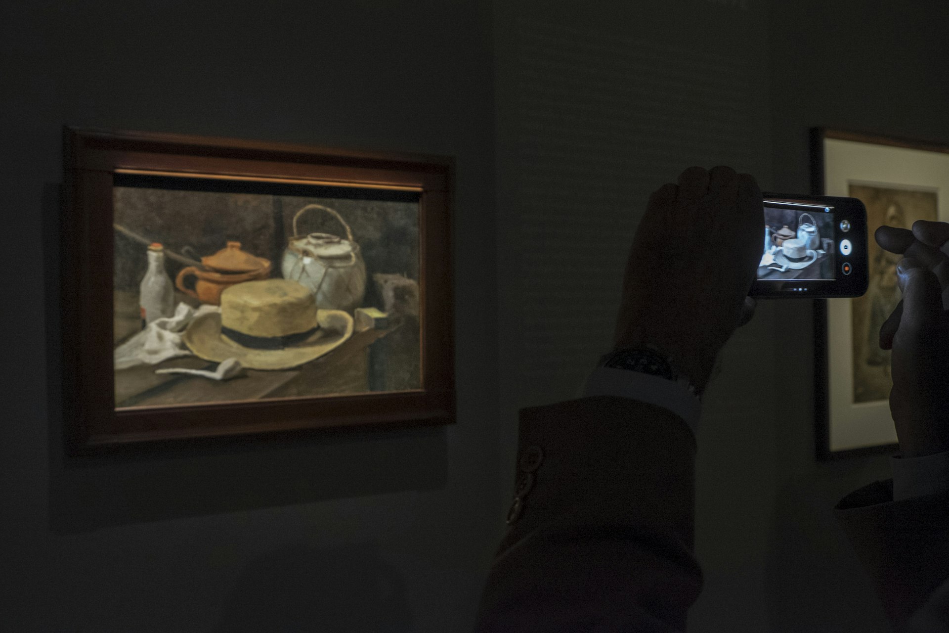 A visitors takes a photo of Van Gogh's painting Still Life with Yellow Straw Hat which hangs in the Kroller-Muller Museum in the Netherlands