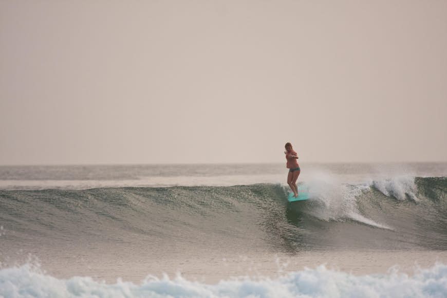 Mary Osborne gliding on a wave at sunset at Ollies Point in costa rica.