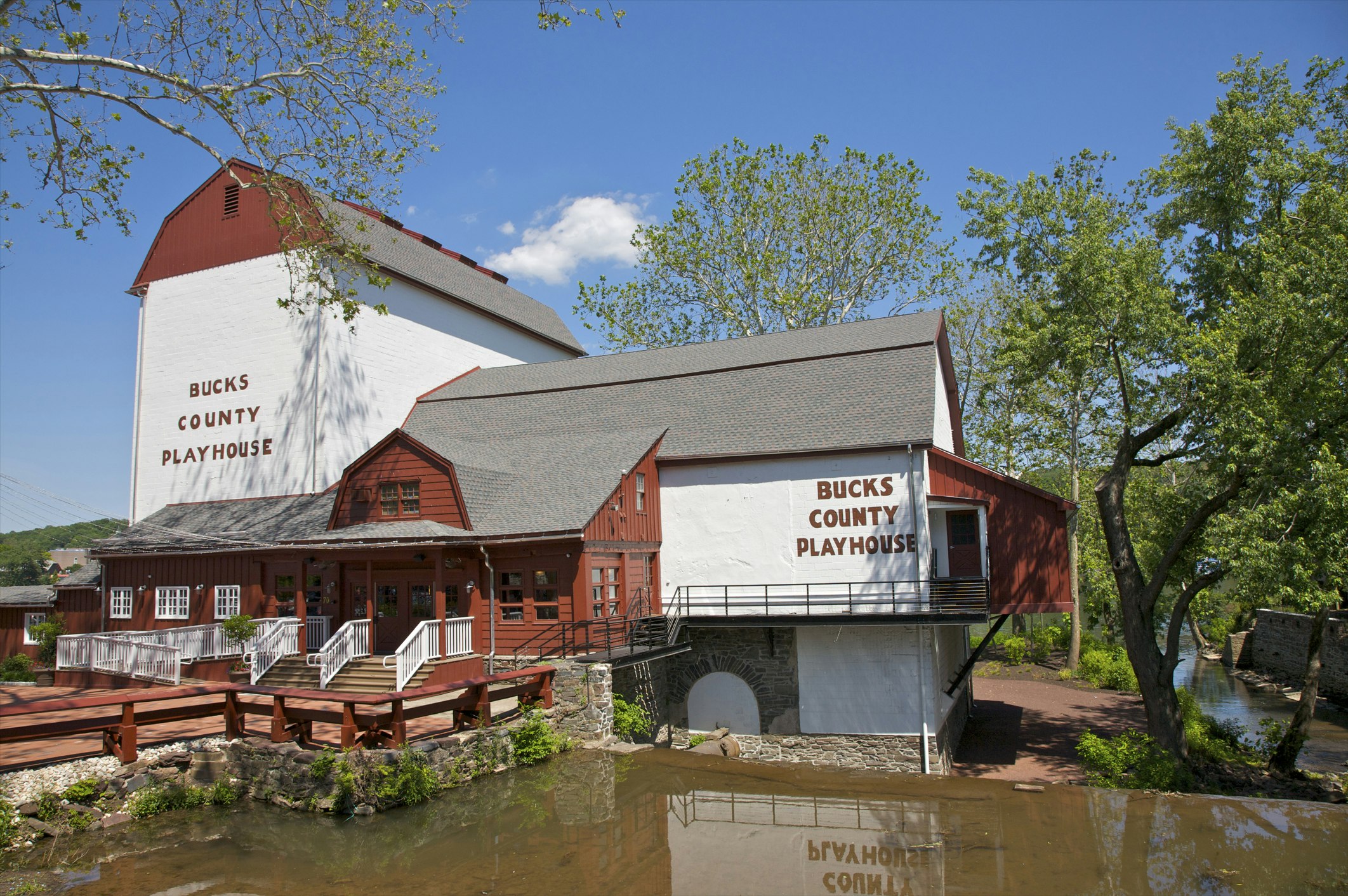 Barn-like red and white theatre near water is the Bucks County Playhouse, New Hope, Bucks County, Pennsylvania, USA. State Theater of Pennsylvania.
