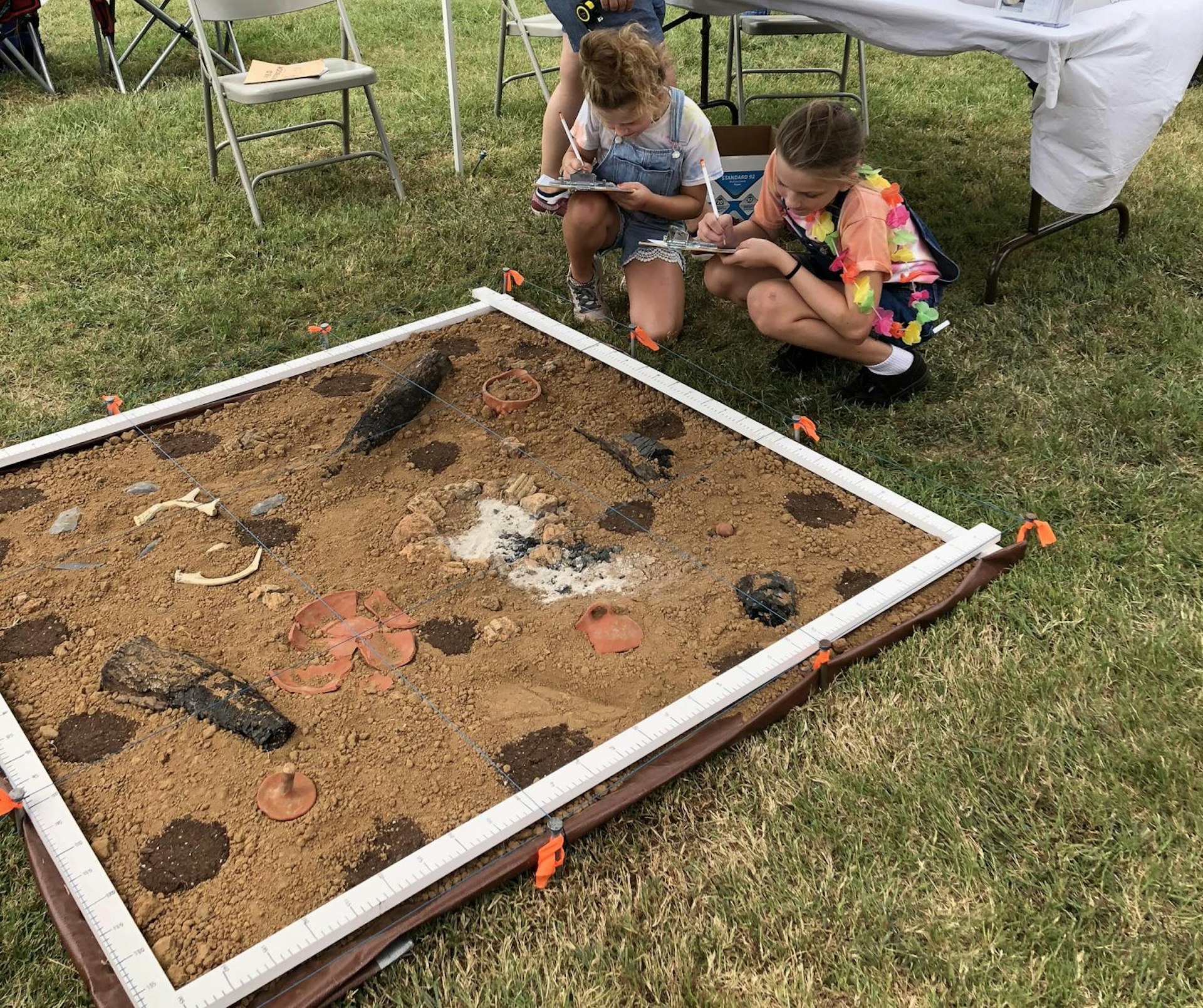 Children learn mapping skills with a replica archaeological house floor during Tennessee Archaeology Day at Bells Bend Park in Nashville, Tenn., Sept. 8, 2018.