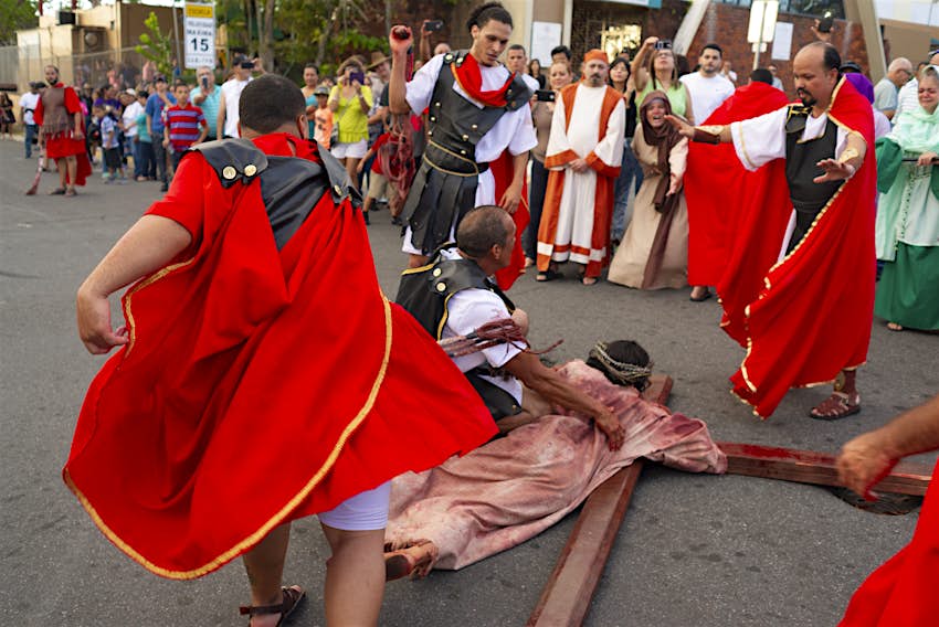 Good Friday procession in Bayamón, Puerto Rico Good Friday procession that depicts a man portraying Jesus Christ holding a wooden cross. He is being guarded by one man and verbally attacked by a trio of other men.