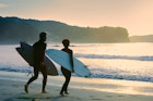 Active senior husband and wife love playing Surfing in Early morning at Izu Peninsula UNESCO Global Geopark Japan