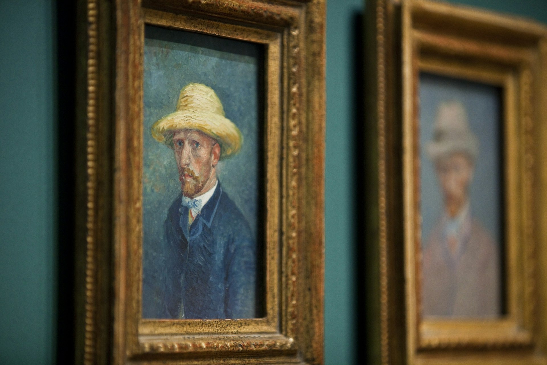 Two framed self-portraits of Vincent Van Gogh, hanging on the wall in the Van Gogh Museum, Amsterdam.