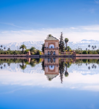 Panoramic view of Saadian pavilion, Menara gardens and Atlas mountains in Marrakech, Morocco, Africa
