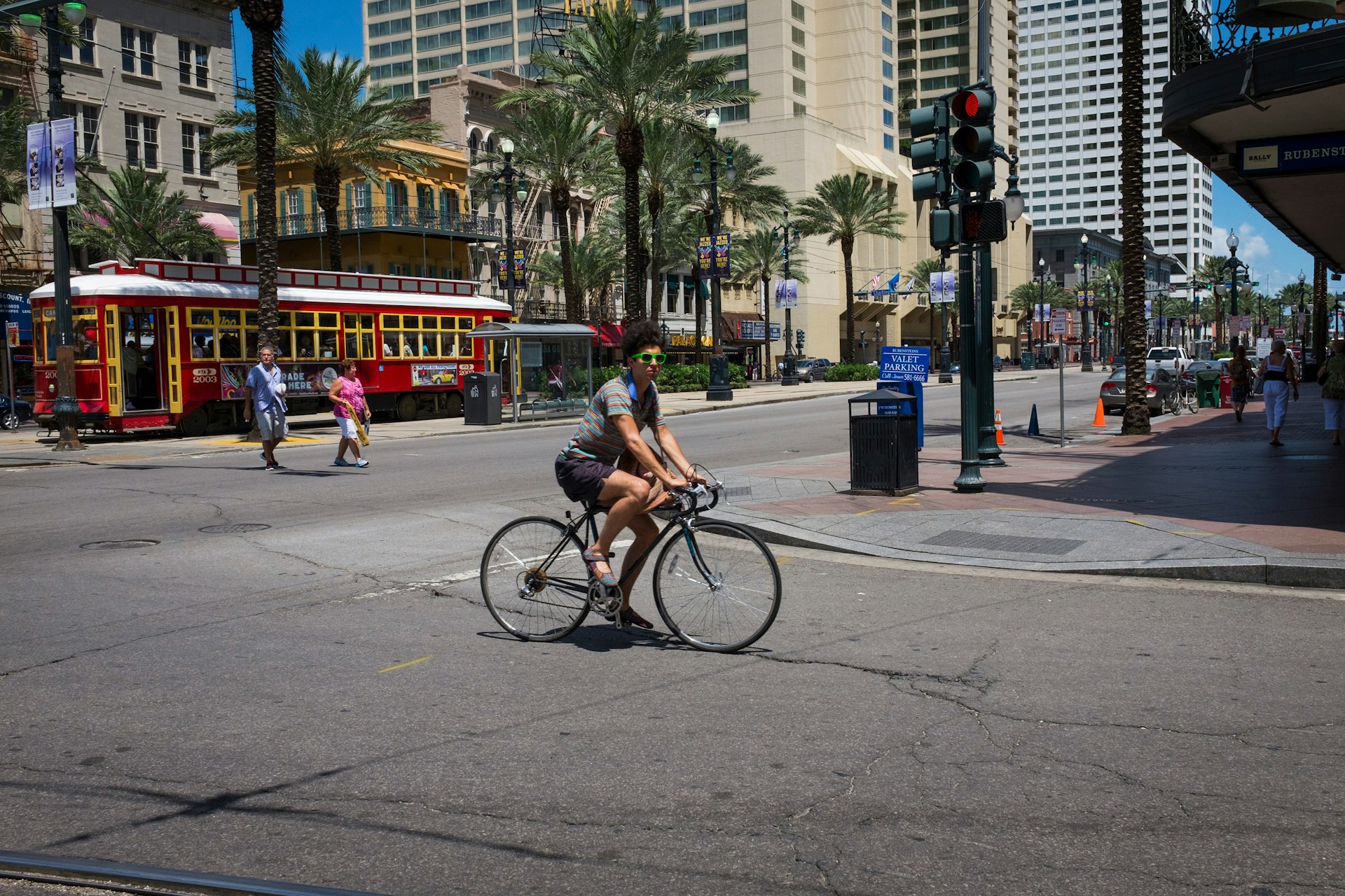 A man rides a bike on Canal Street in downtown New Orleans