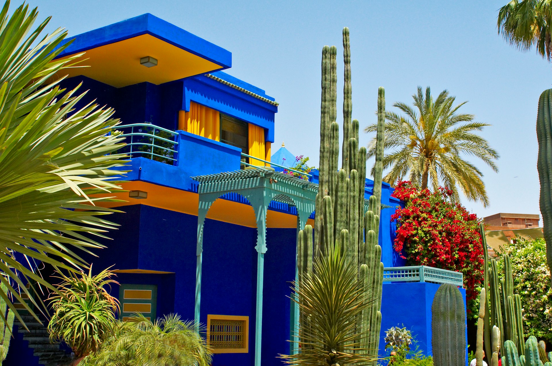 Blue building with yellow detail in a lush garden