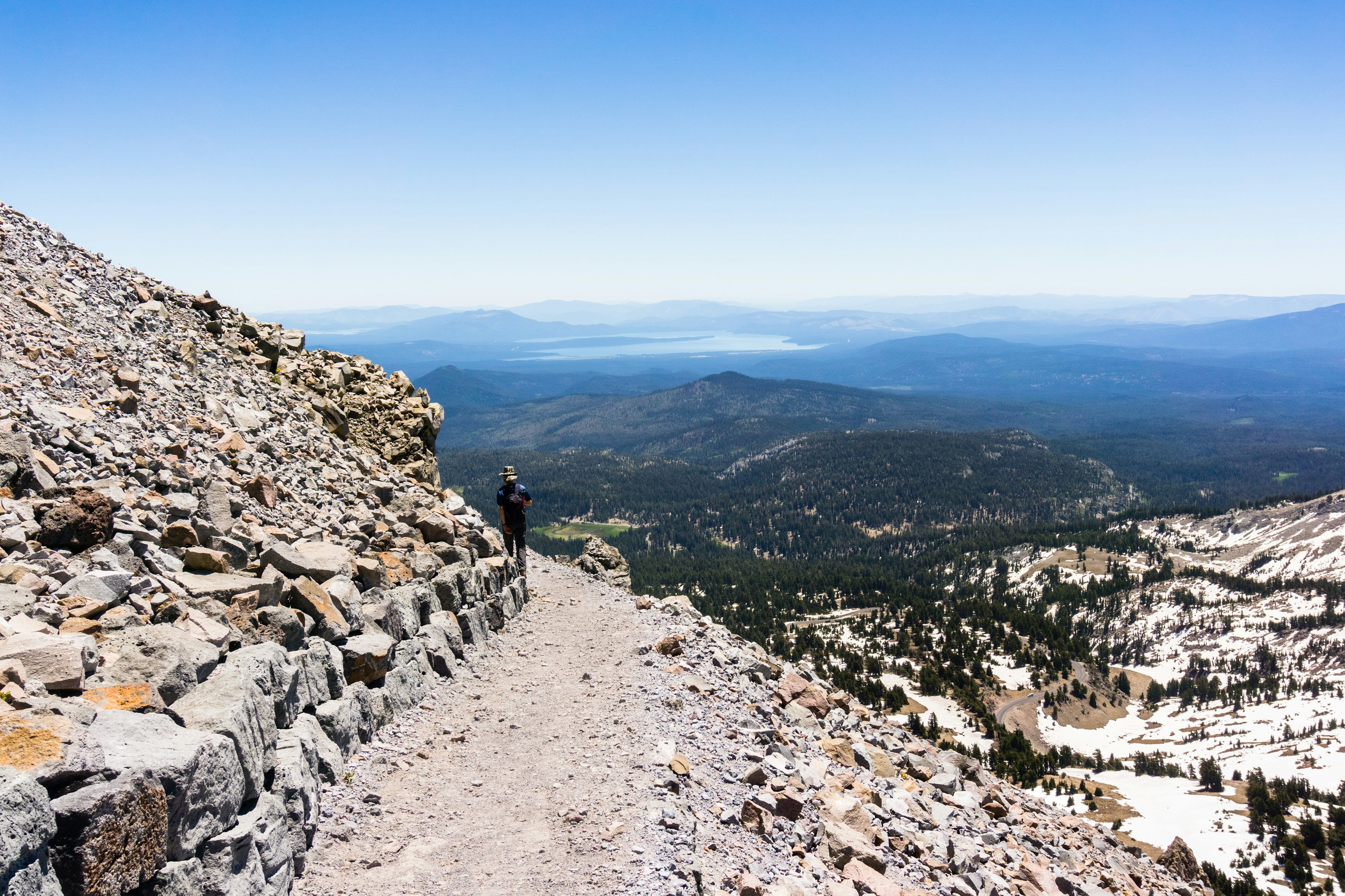 A hiker walks a rocky trail to Lassen Peak in the Lassen Volcanic National Park.