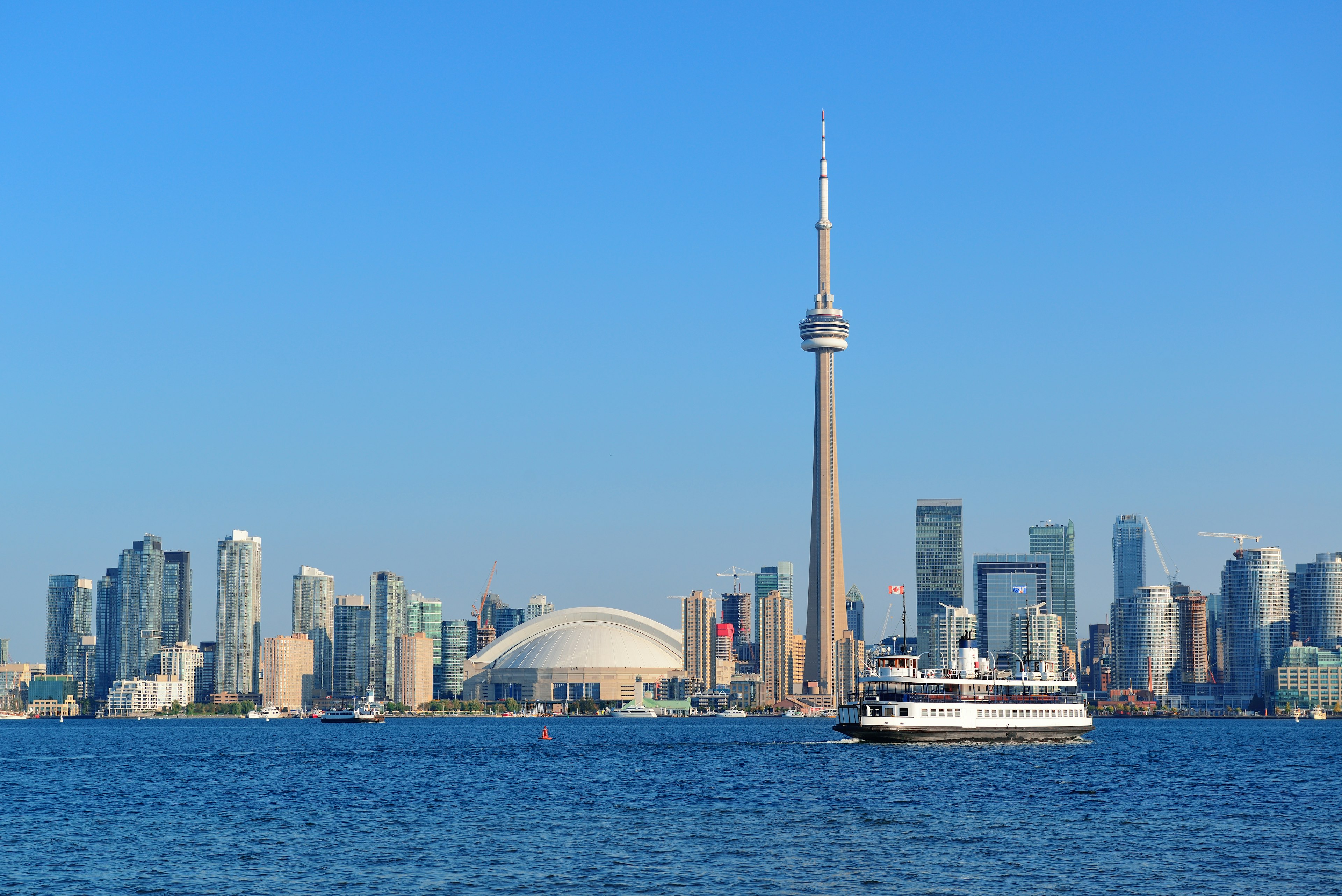 A ferry passes in front of the CN Tower, a top stop for families