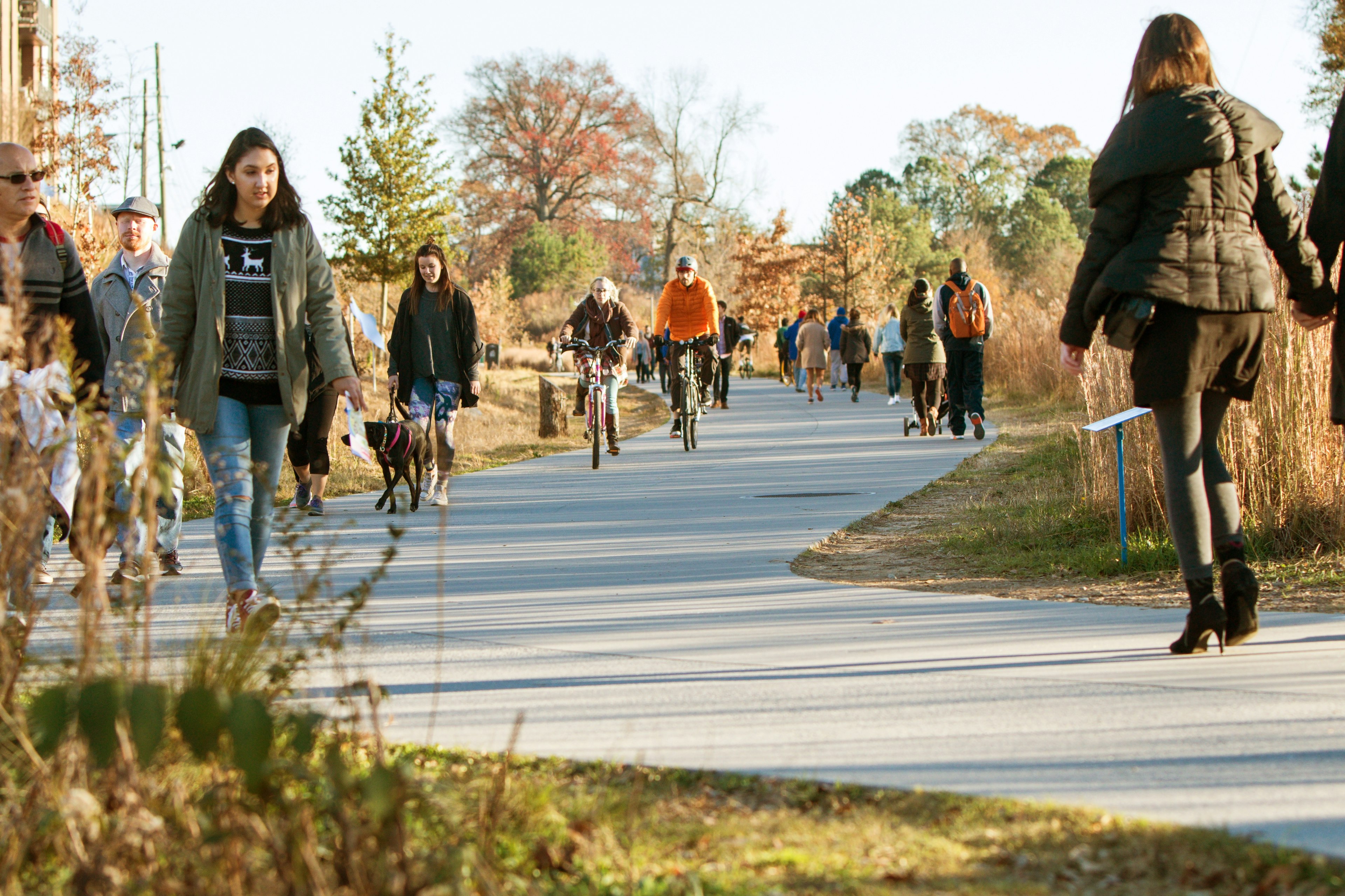 People walk, run and cycle along a pathway