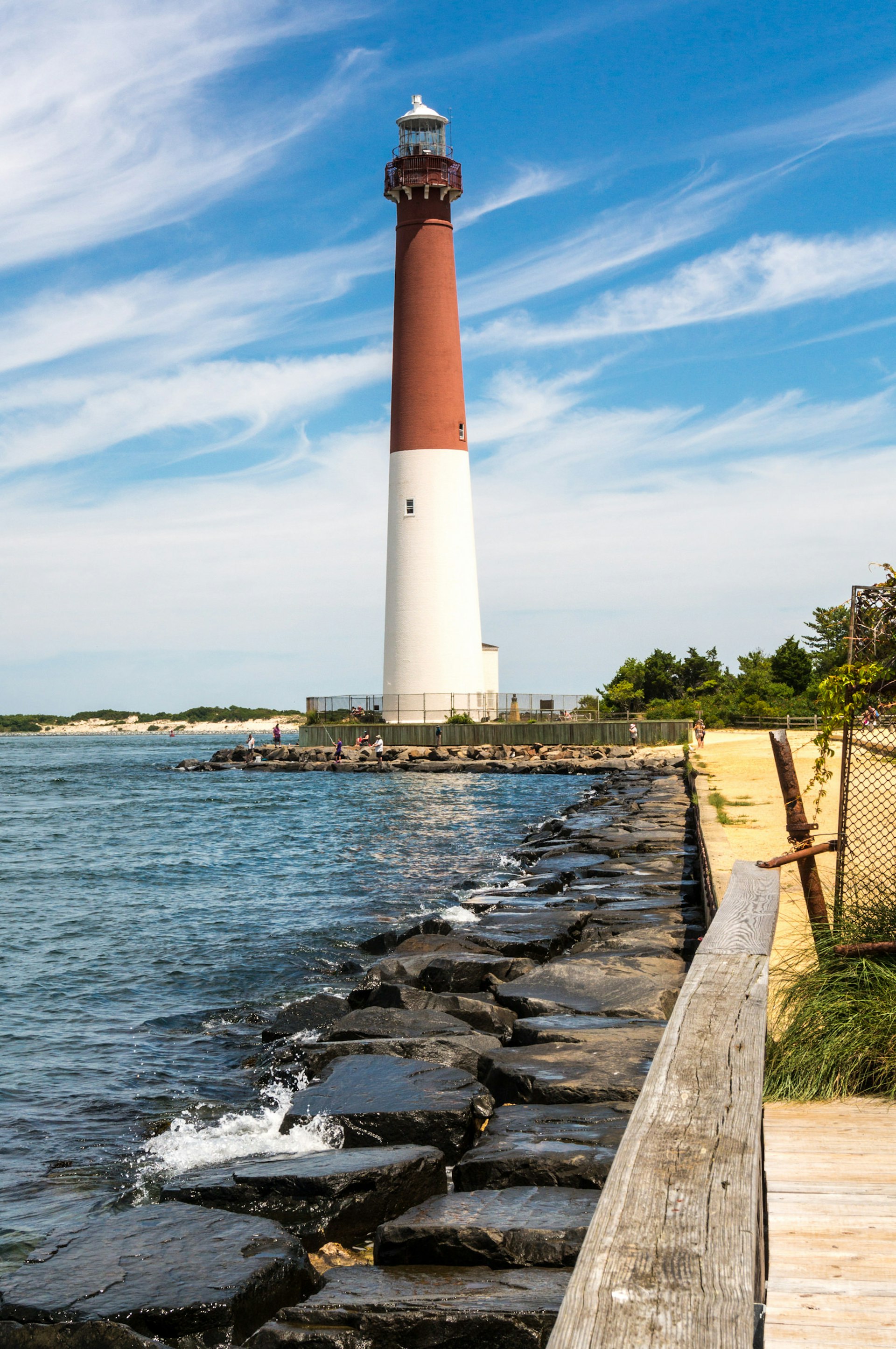 Tall red-and-white lighthouse standing on the shore