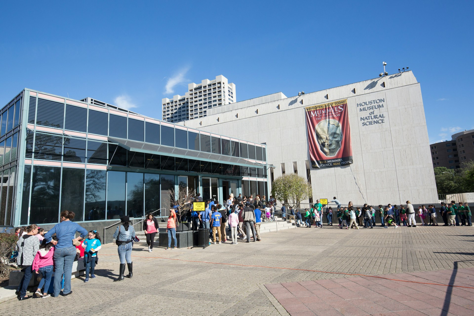 An exterior view of the entrance to the Houston Museum of Natural Science with people crowding around