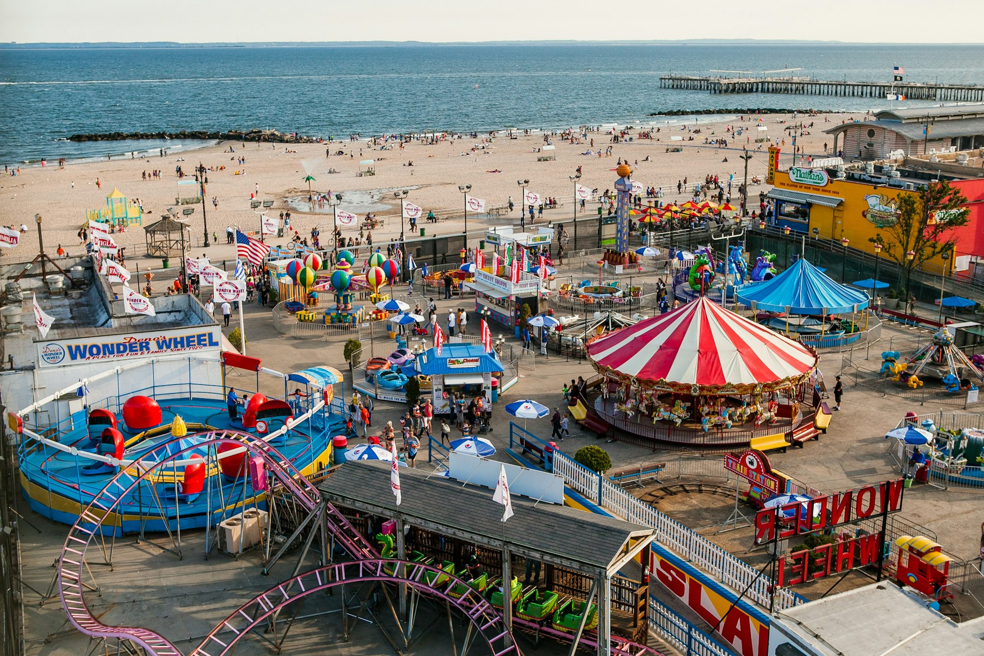 Aerial of Coney Island Beach and amusement park, including carousels and food stands