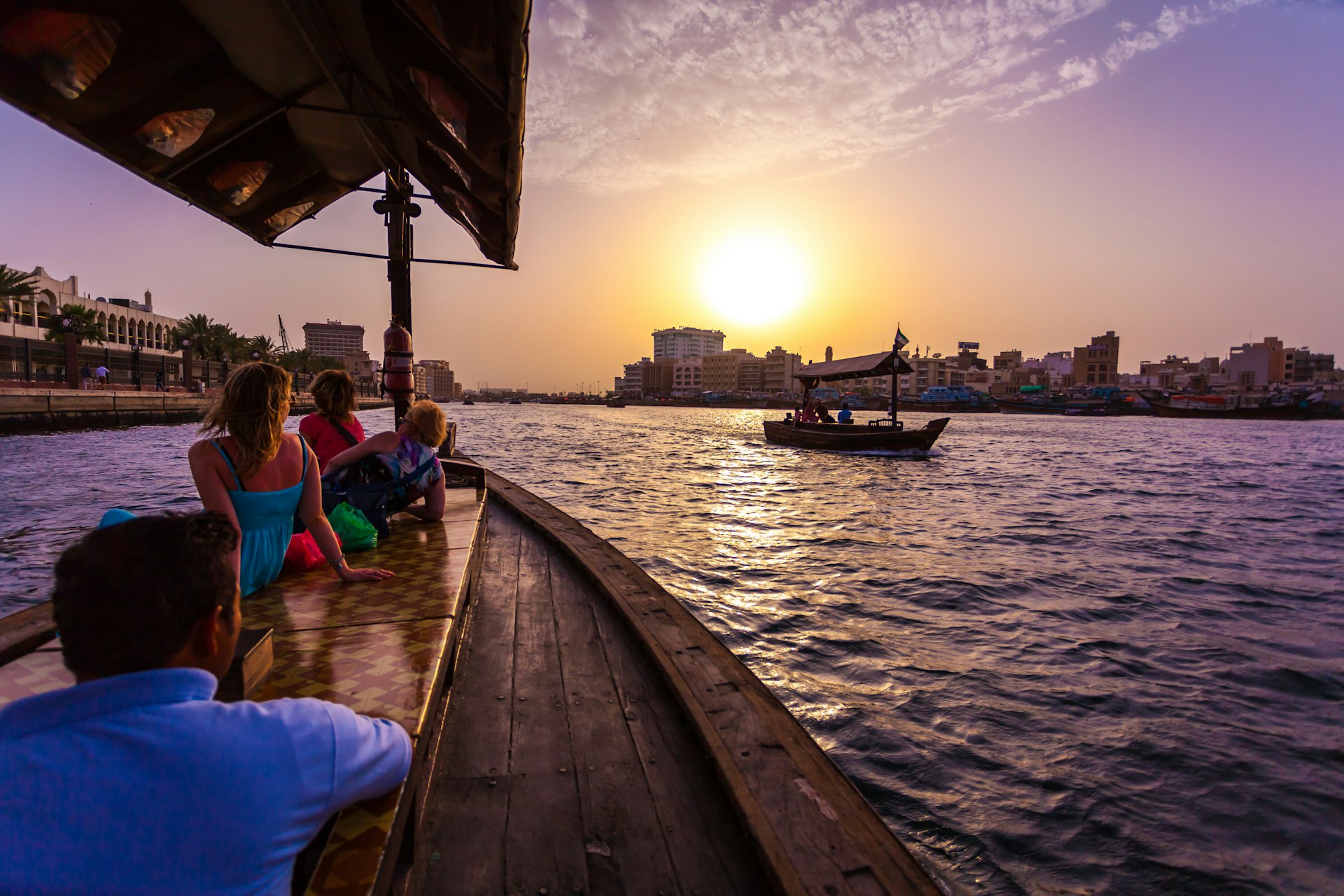 Visitors ride an abra across Dubai Creek