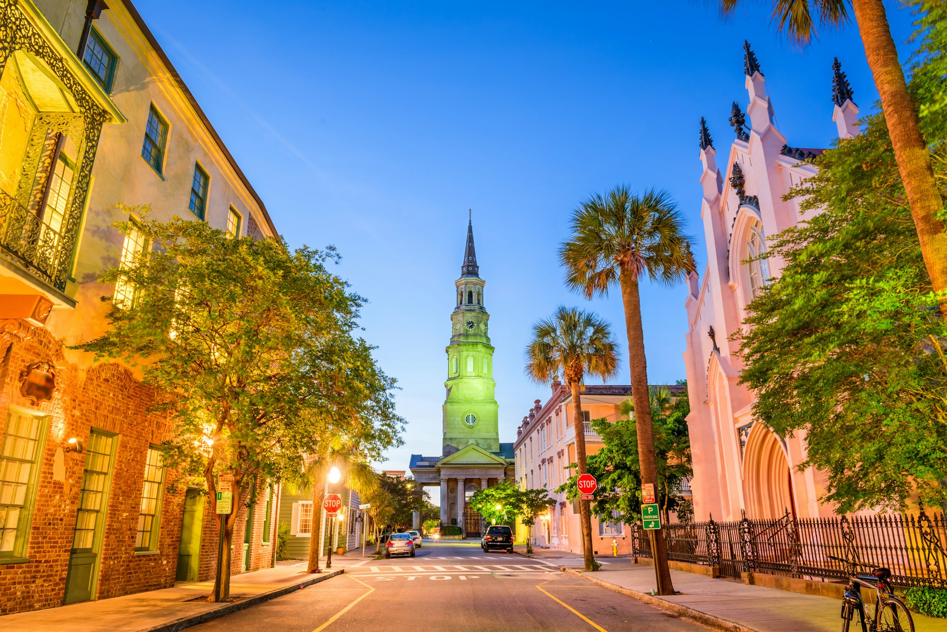 A historic street in Charleston, South Carolina, is illuminated by lights at dusk