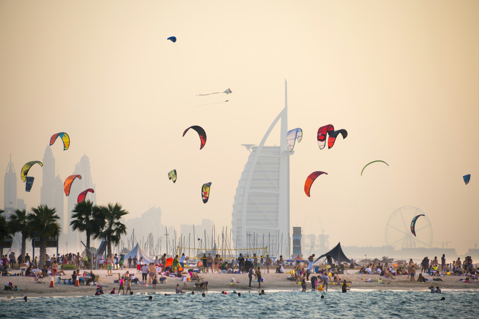 A kite beach full of kite surfers in Jumeirah with the Burj Al Arab in the background.