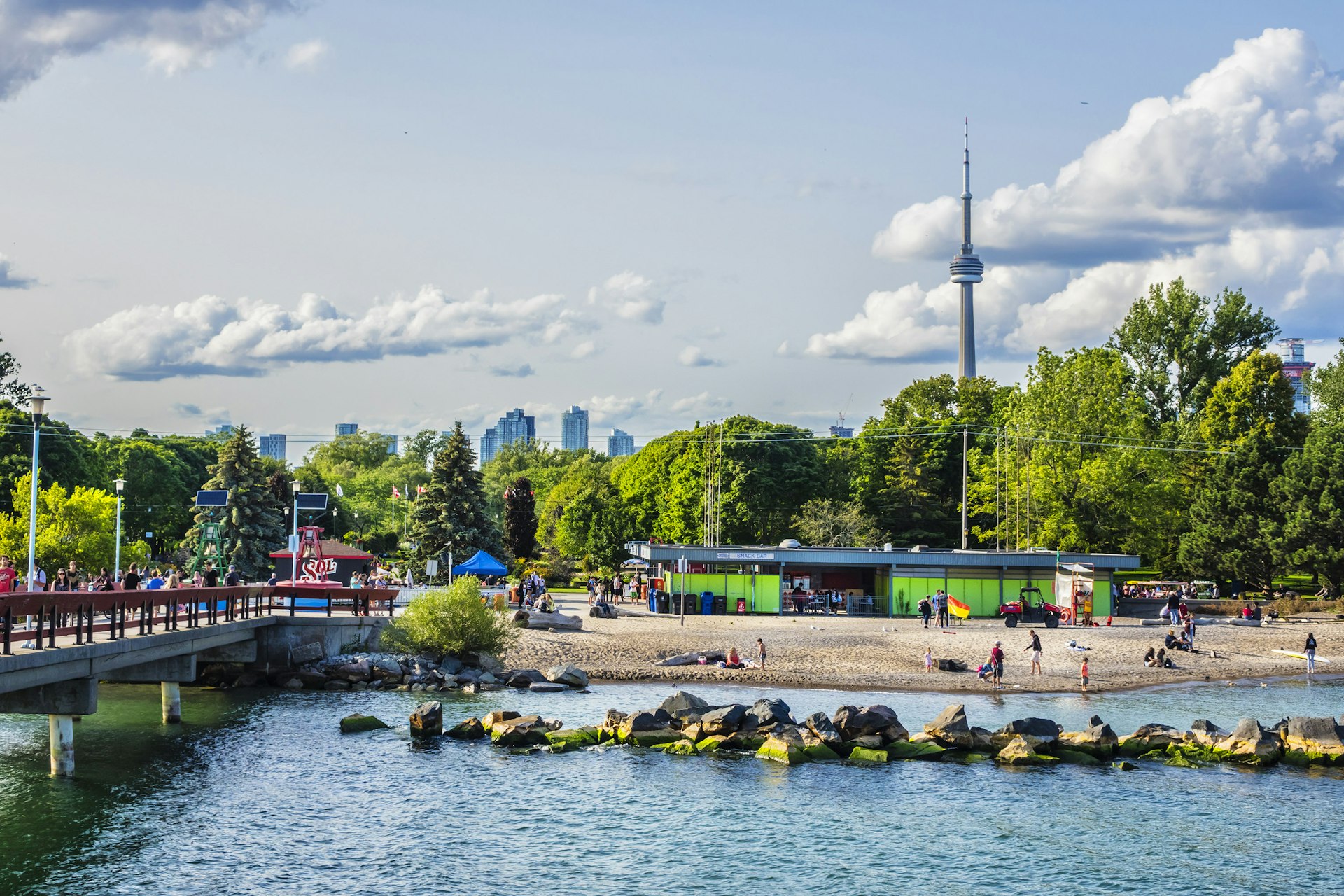 A pier leading to an amusement park next to a beach