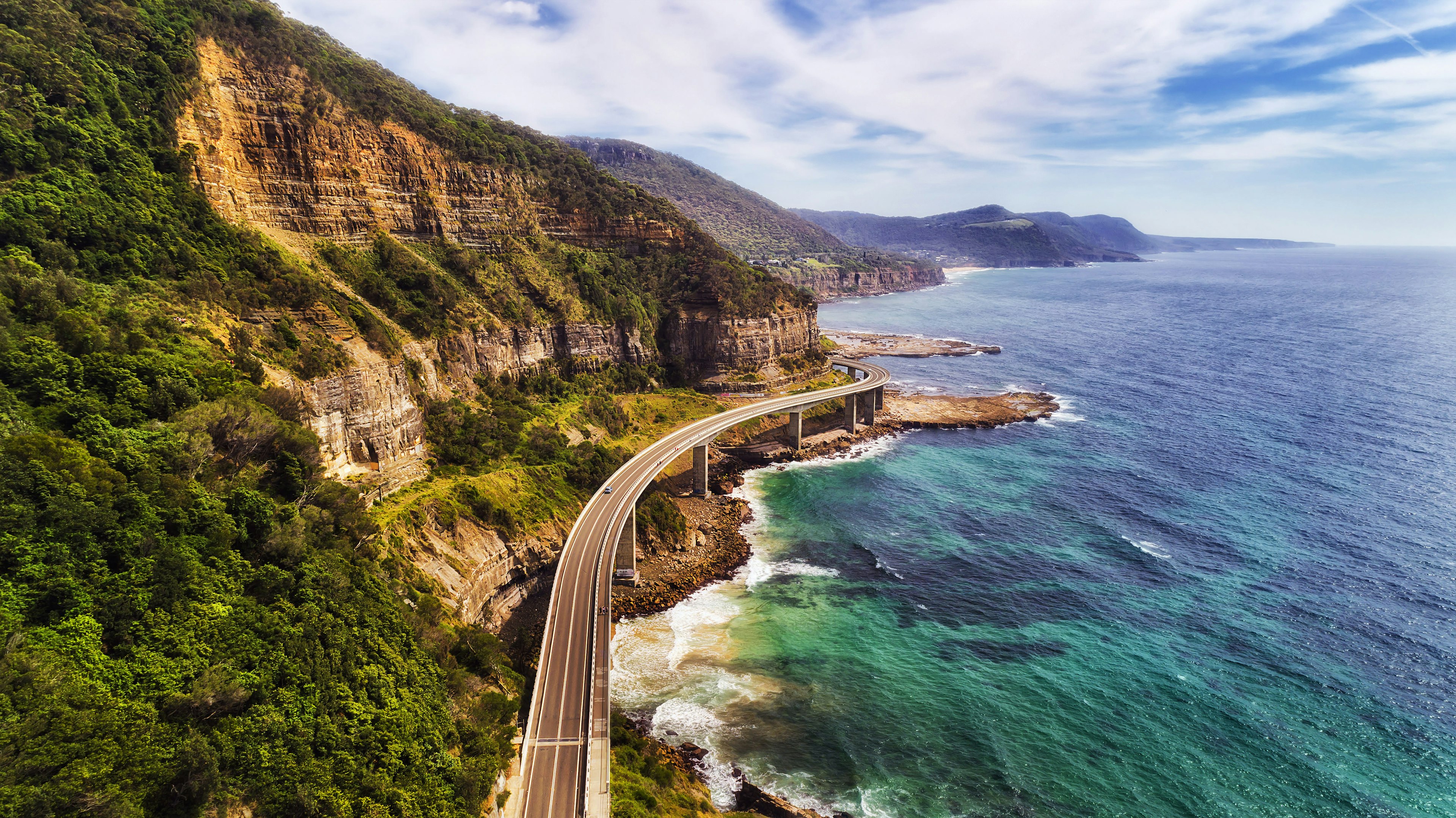 Aerial view of the Sea Cliff Bridge near steep sandstone cliffs on the Grand Pacific Drive, New South Wales, Australia