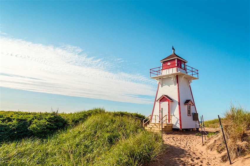 Stanhope Beach is an idyllic retreat A lighthouse on a grassy sand dune, with blue skies above