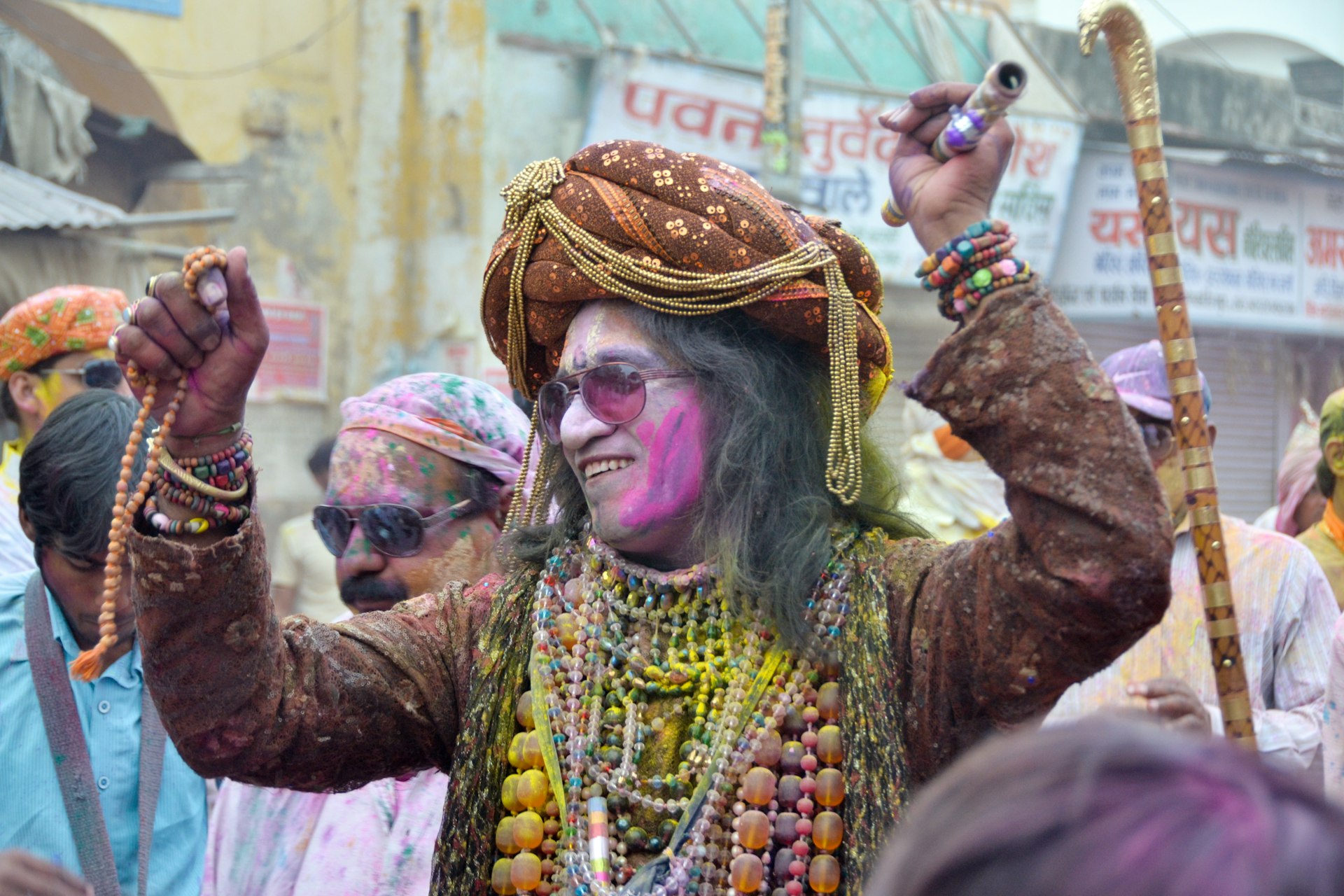 A man in sunglasses, covered in paint, takes part in the Holi festival in Mathura, India