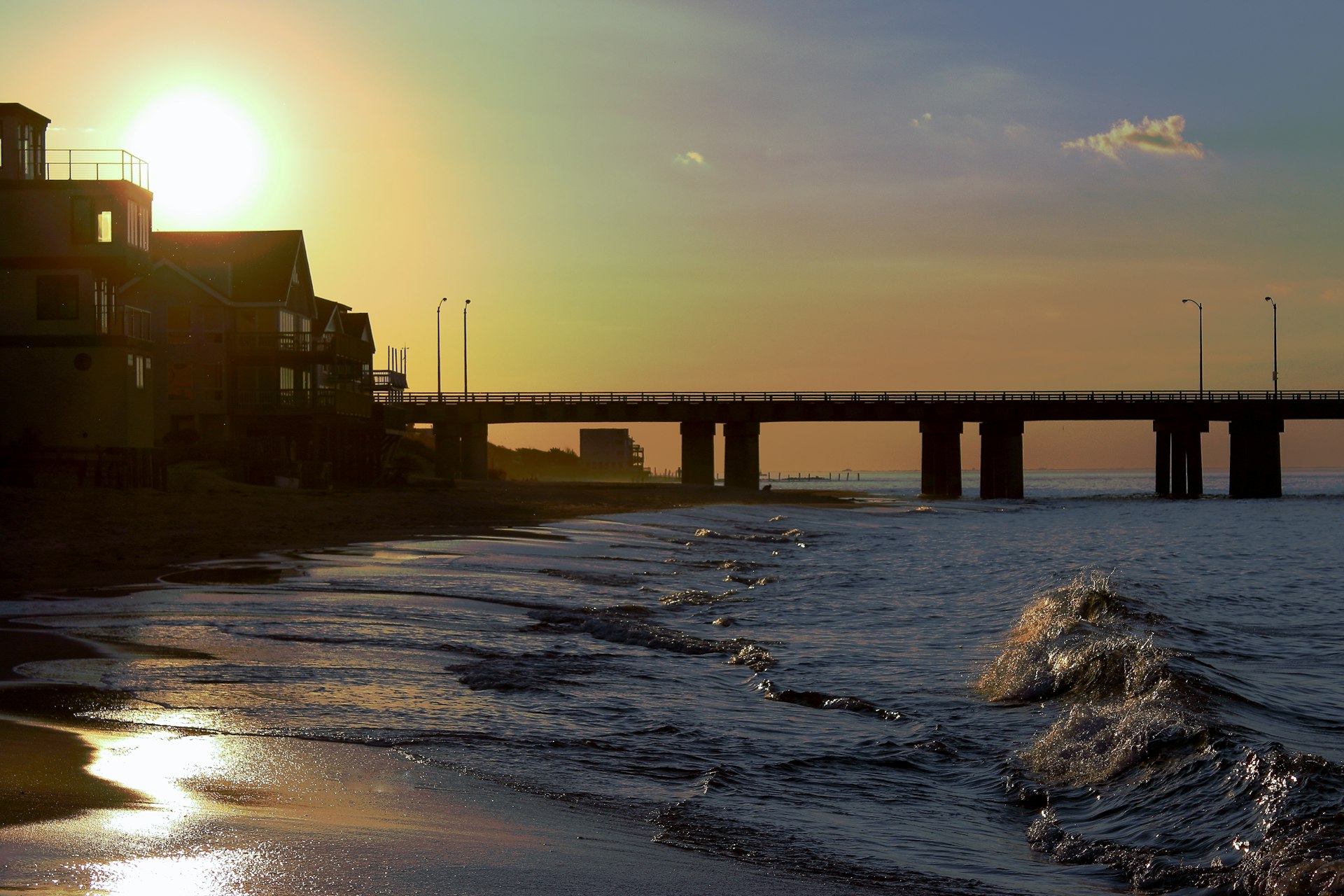 A beach scene with a bridge in the background
