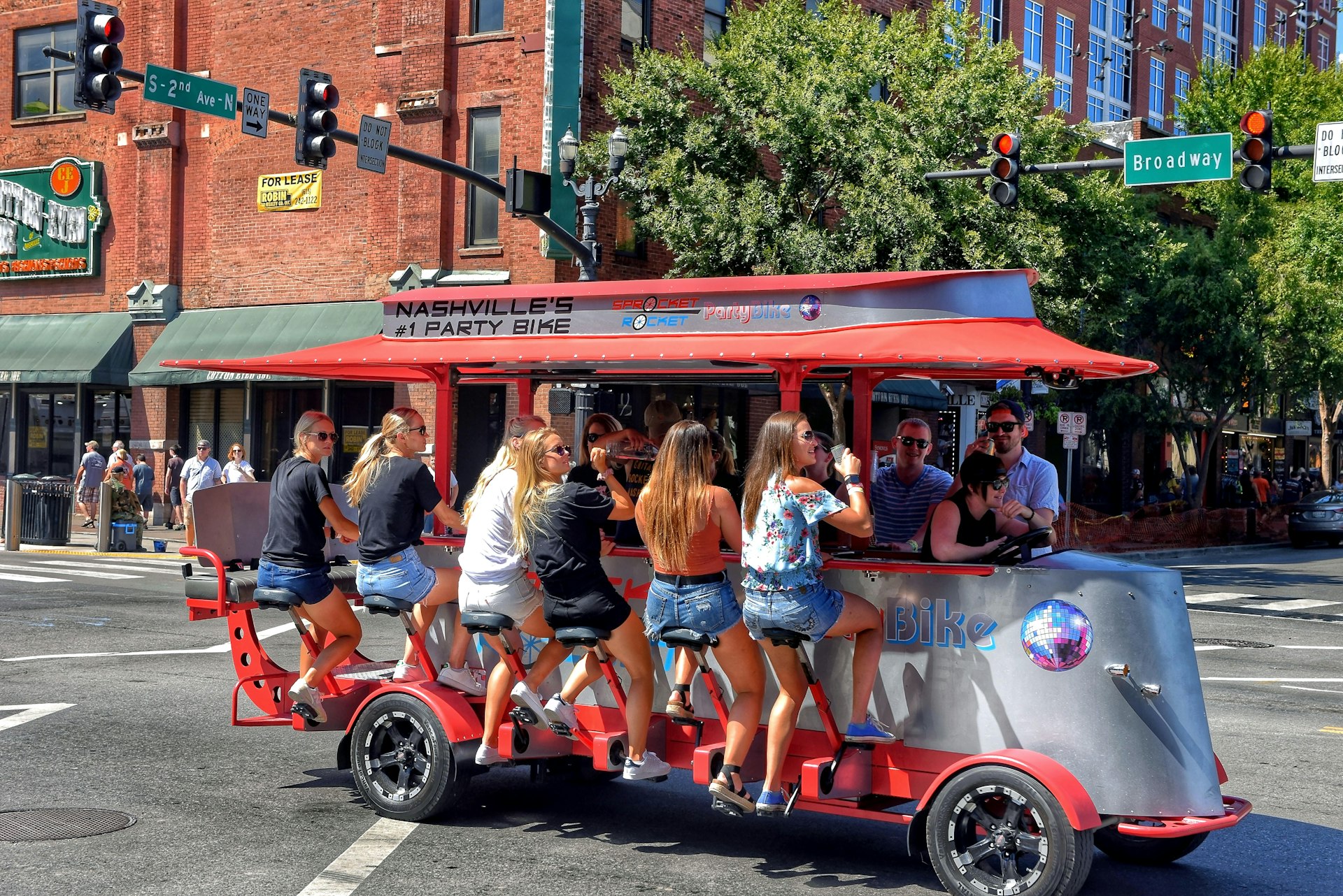 Nashville, TN, USA - September 21, 2019:  Revelers enjoy drinks on a Sprocket Rocket pedal bike tavern on Broadway Street.  These vehicles are powered