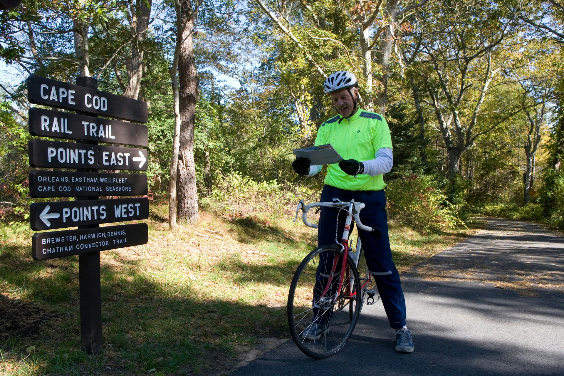 A cyclist in front of a sign at Nickerson State Park on the Cape Cod Rail Trail 