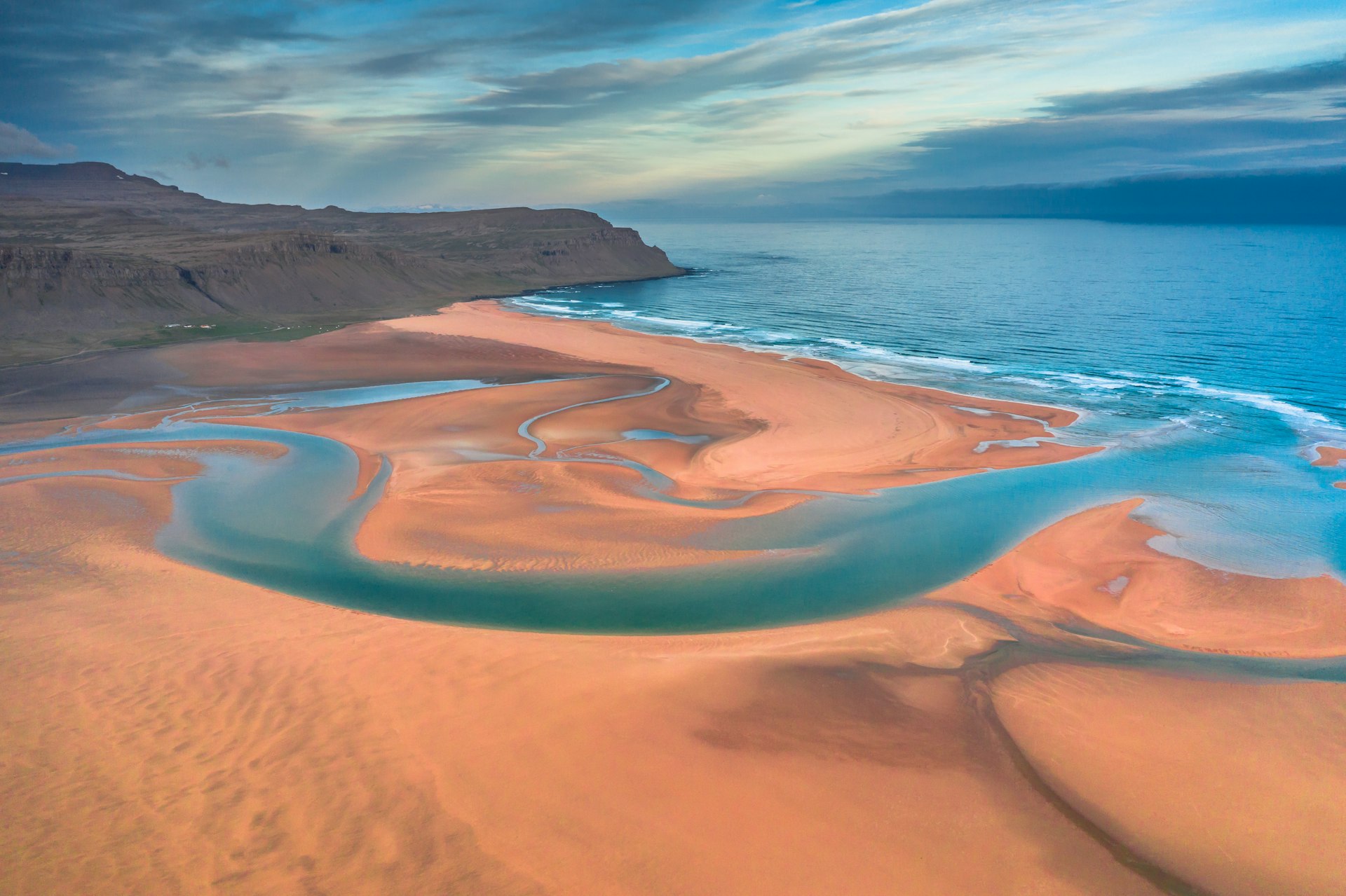 Aerial drone view of azure water streams and reddish-yellow sand