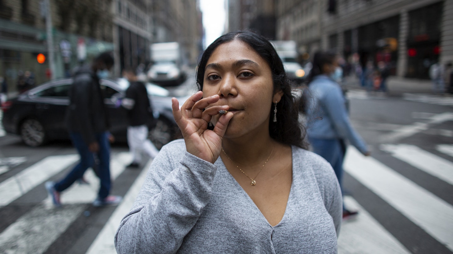 Eliana Miss Illi, General Manager of Weed World poses as she smokes a joint on 7th Avenue in Midtown New York City, March 31, 2021. - New York Governor Andrew Cuomo signed legislation legalizing recreational marijuana on March 31. 2021, with a large chunk of tax revenues from sales set to go to minority communities. New York joins 14 other US states and the District of Columbia in permitting cannabis after lawmakers in both state chambers, where Cuomo's Democratic Party holds strong majorities, backed the bill on March 30. (Photo by Kena Betancur / AFP) (Photo by KENA BETANCUR/AFP via Getty Images)
