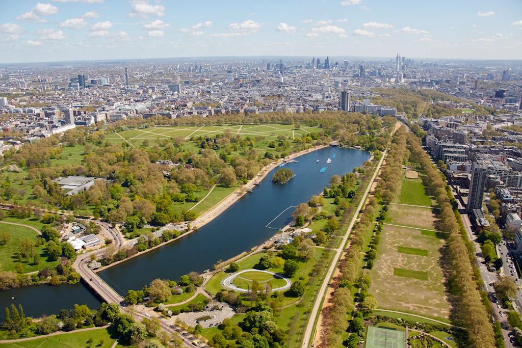 Aerial shot of a large park dominated by a central L-shaped lake