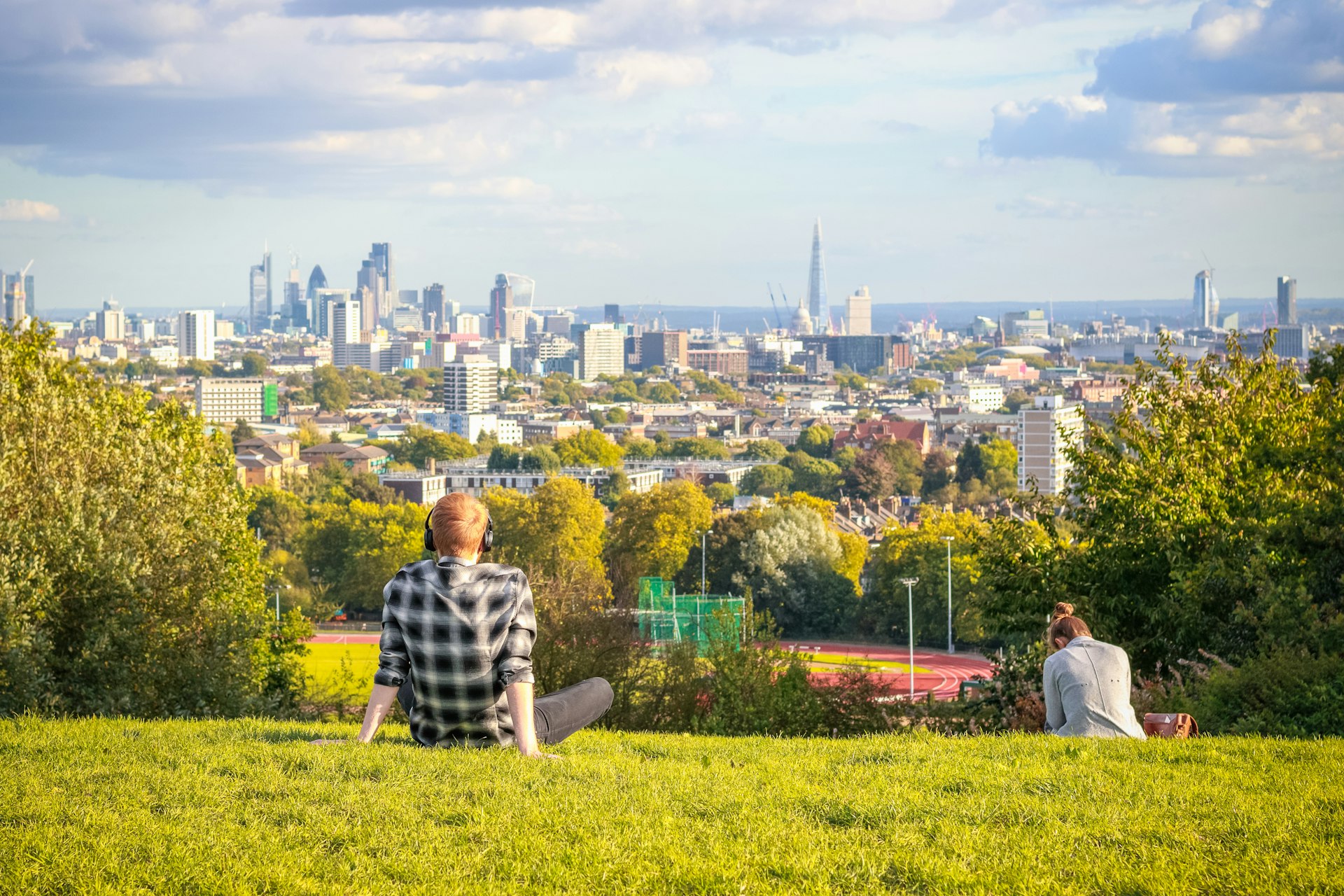 Visitors looking over London city skyline from Hampstead Heath