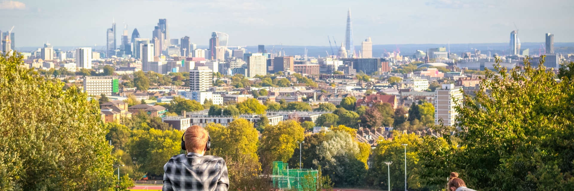 Visitors looking over London city skyline from Hampstead Heath.