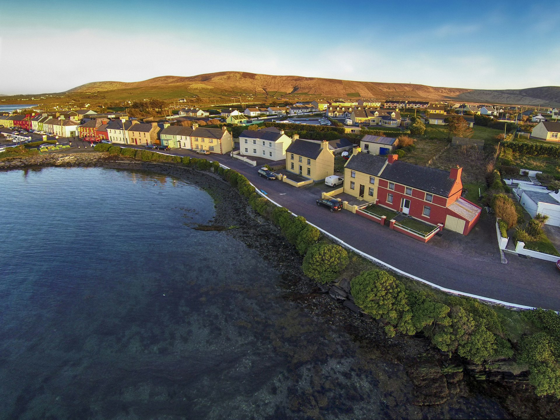 A coastal road runs along a small Irish village. 
