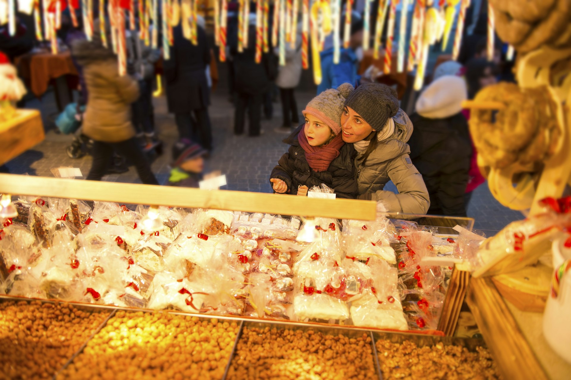 A child stands at a sweet stall at a Christmas market