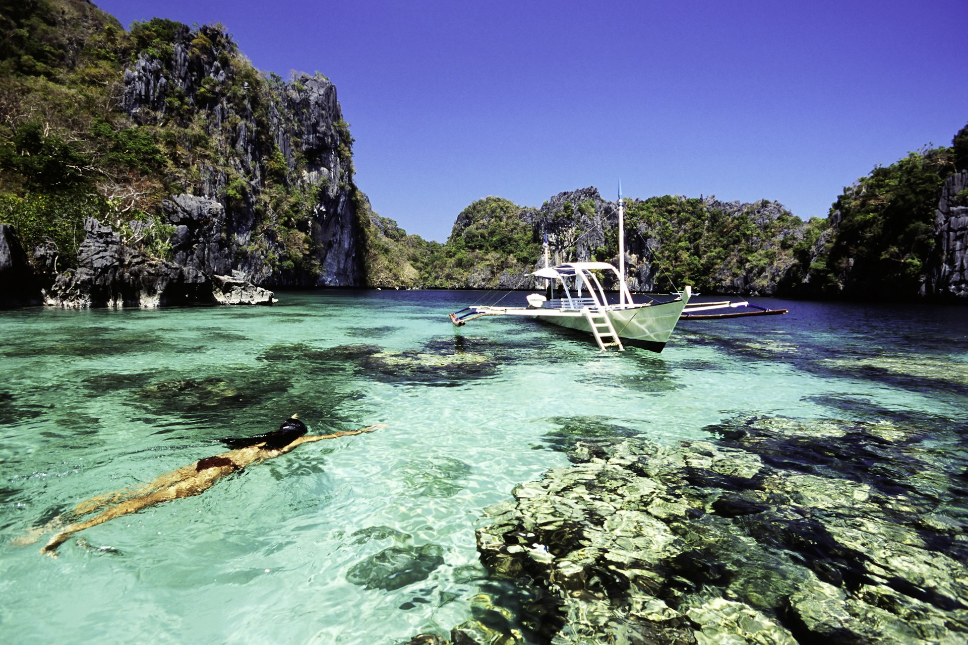 A woman snorkels in a tropical lagoon. 