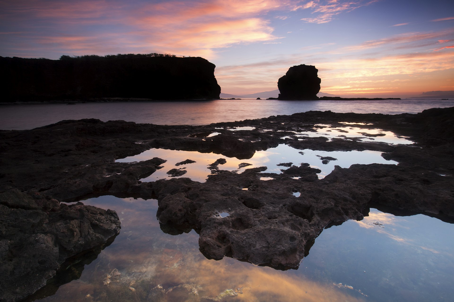 A rocky shoreline at sunset. 
