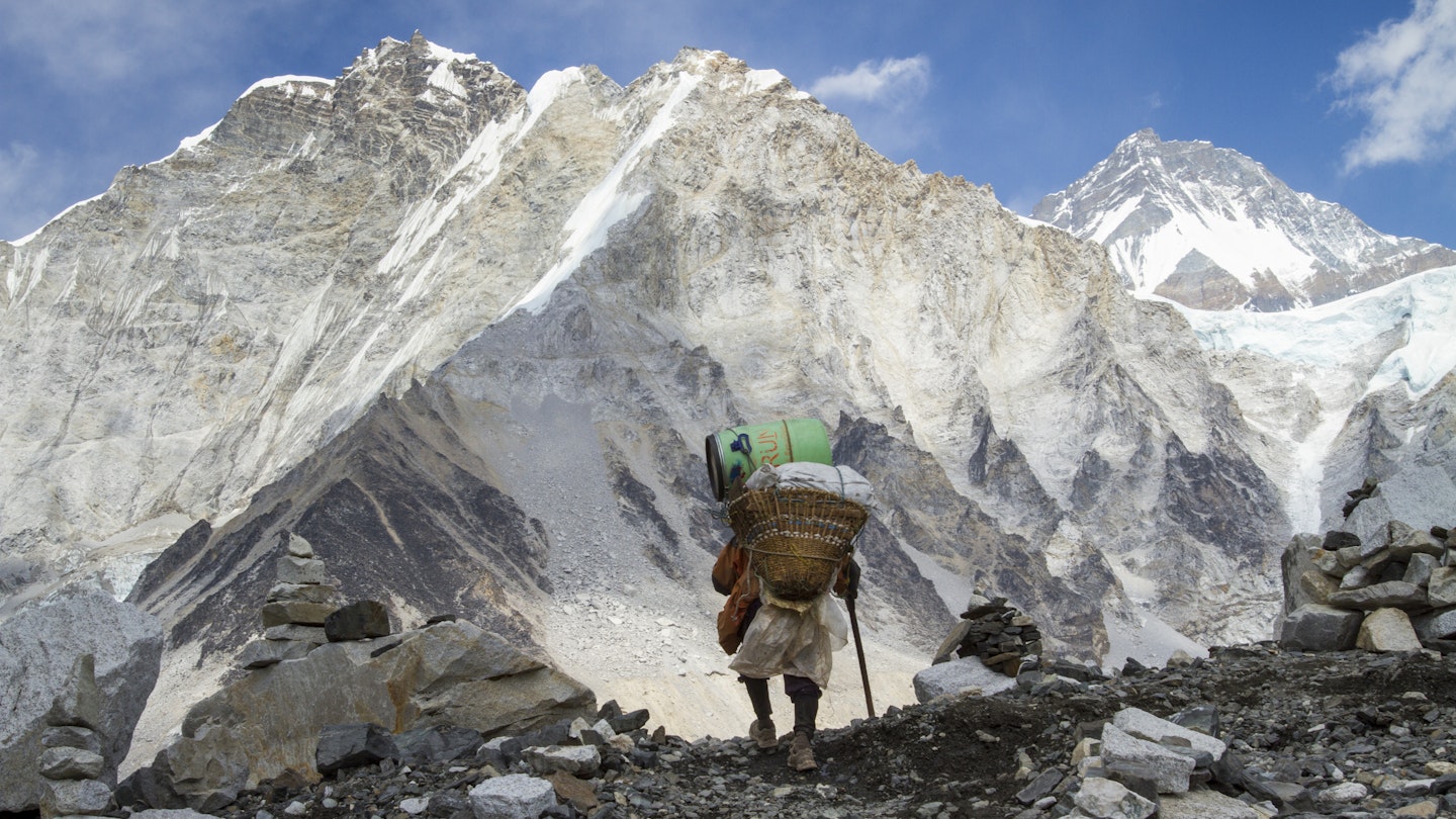 Porter arriving at Mount Everest Base Camp above the Khumbu Glacier in Nepal