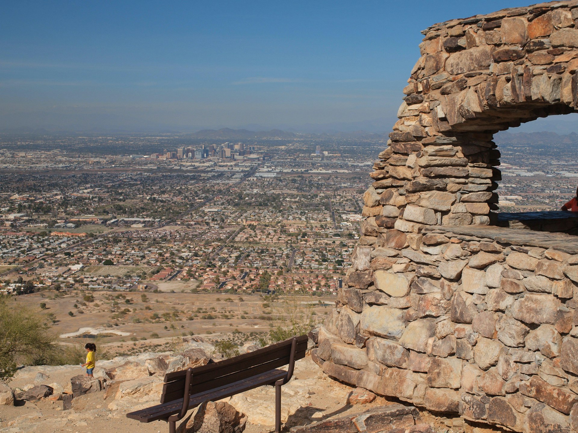 A bench at South Mountain Park offers a lookout onto the Phoenix skyline and desert in the distance