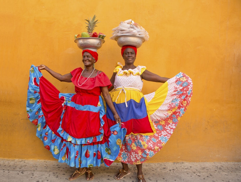 Two Palenqueras, colourfully dressed fruit vendors, in Old Town in Cartagena, Colombia.