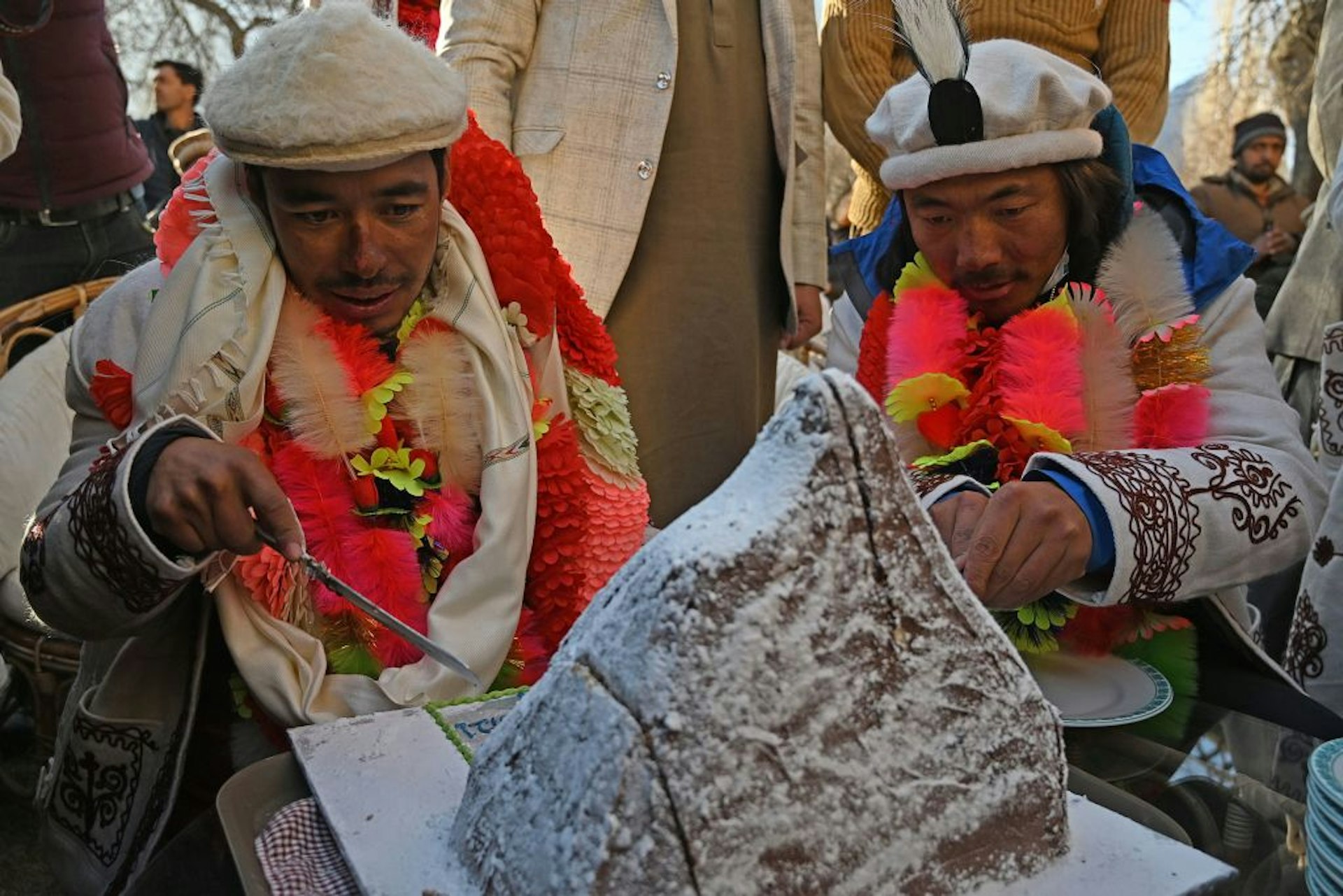 Nepal's climbers Nirmal Purja (L) and Mingma Sherpa (R) cut a cake upon their arrival after becoming the first to summit Pakistan's K2 in winter, during a ceremony at Shigar district in the Gilgit-Baltistan region of northern Pakistan 