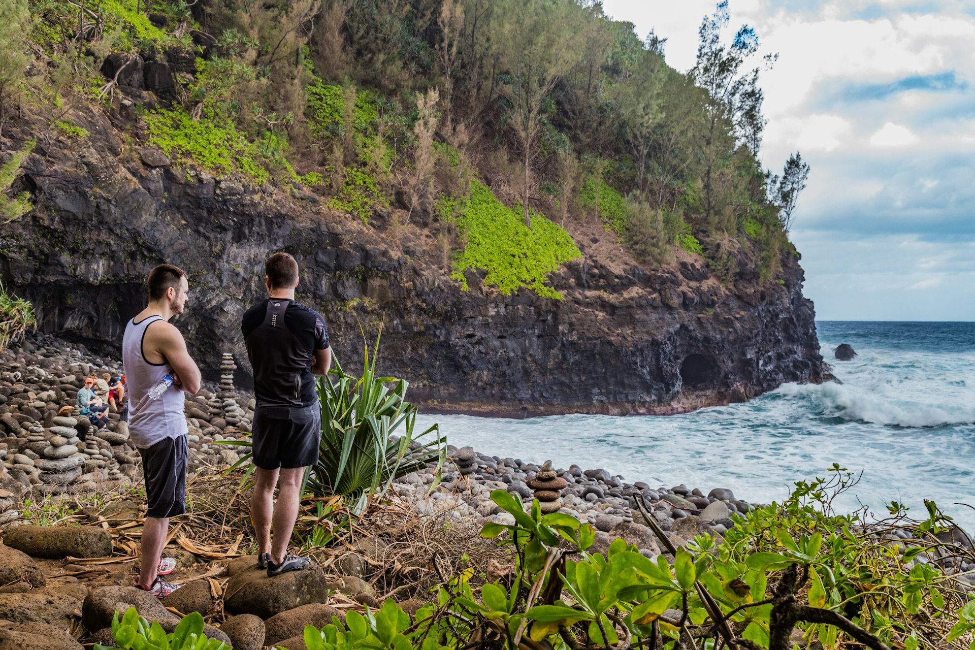 Two men looking at Hanakapi'ai Beach on the Na Pali Coast of Kauai
