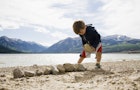 USA, Colorado, Boy (2-3) with rocks on beach