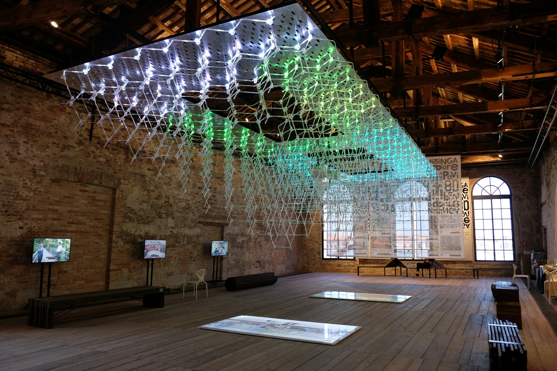 Installation artwork hangs from the ceiling in a warehouse-like room