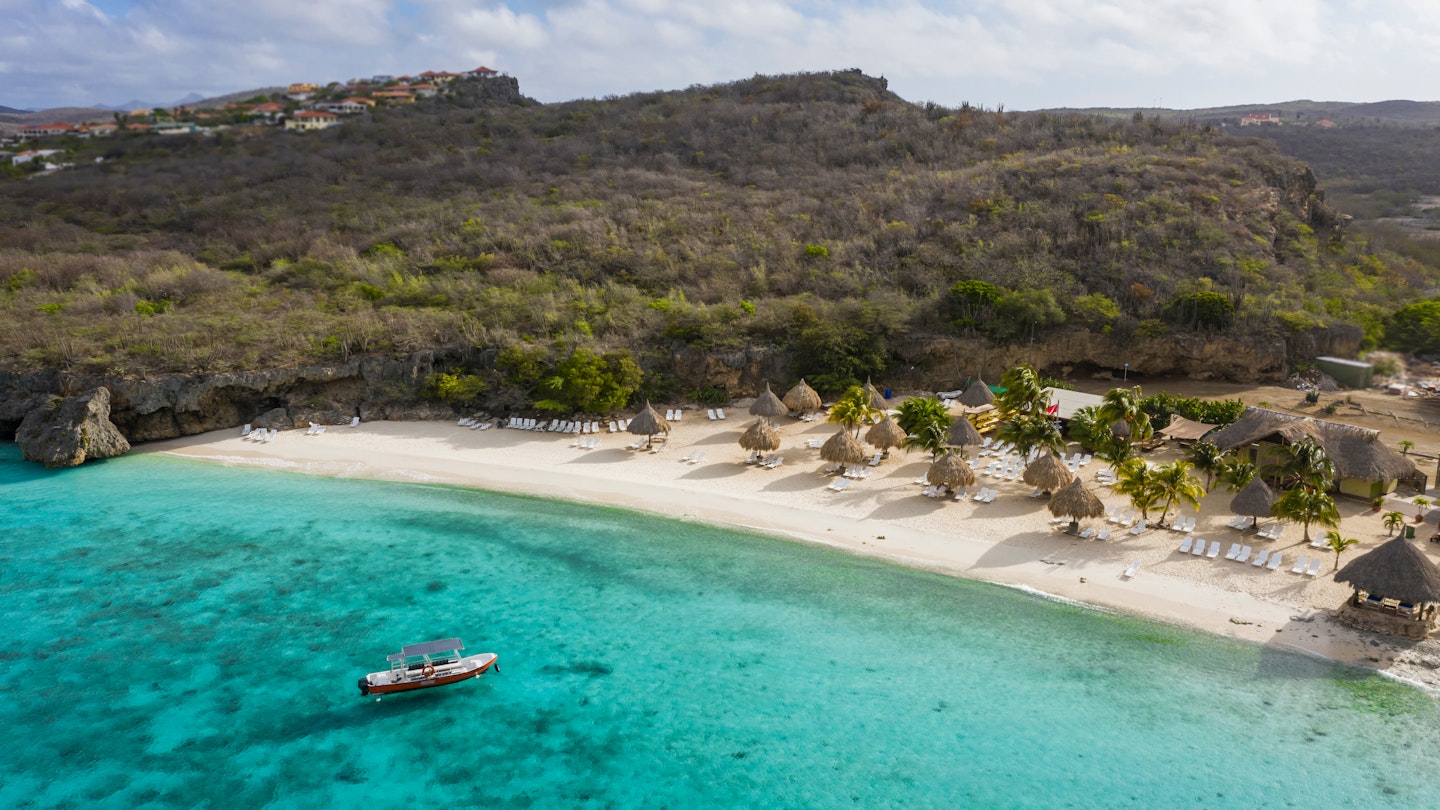 Aerial view of coast of Curaçao in the Caribbean Sea with turquoise water, white sandy beach and beautiful coral reef at Playa Cas Abao