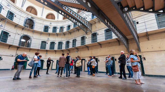 August 2019: A tour group on the floor of the Victorian main hall in the Kilmainham Gaol, a former prison which is now a museum. 